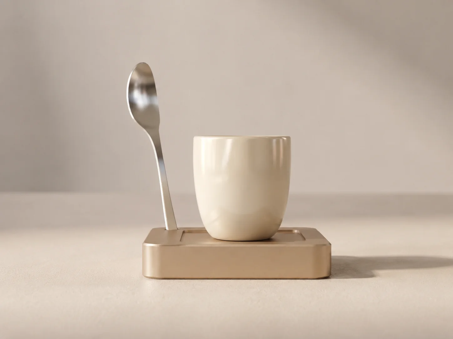 Front view of the NOÉ Solo Saucer, cream cup and upright steel spoon on a champagne base