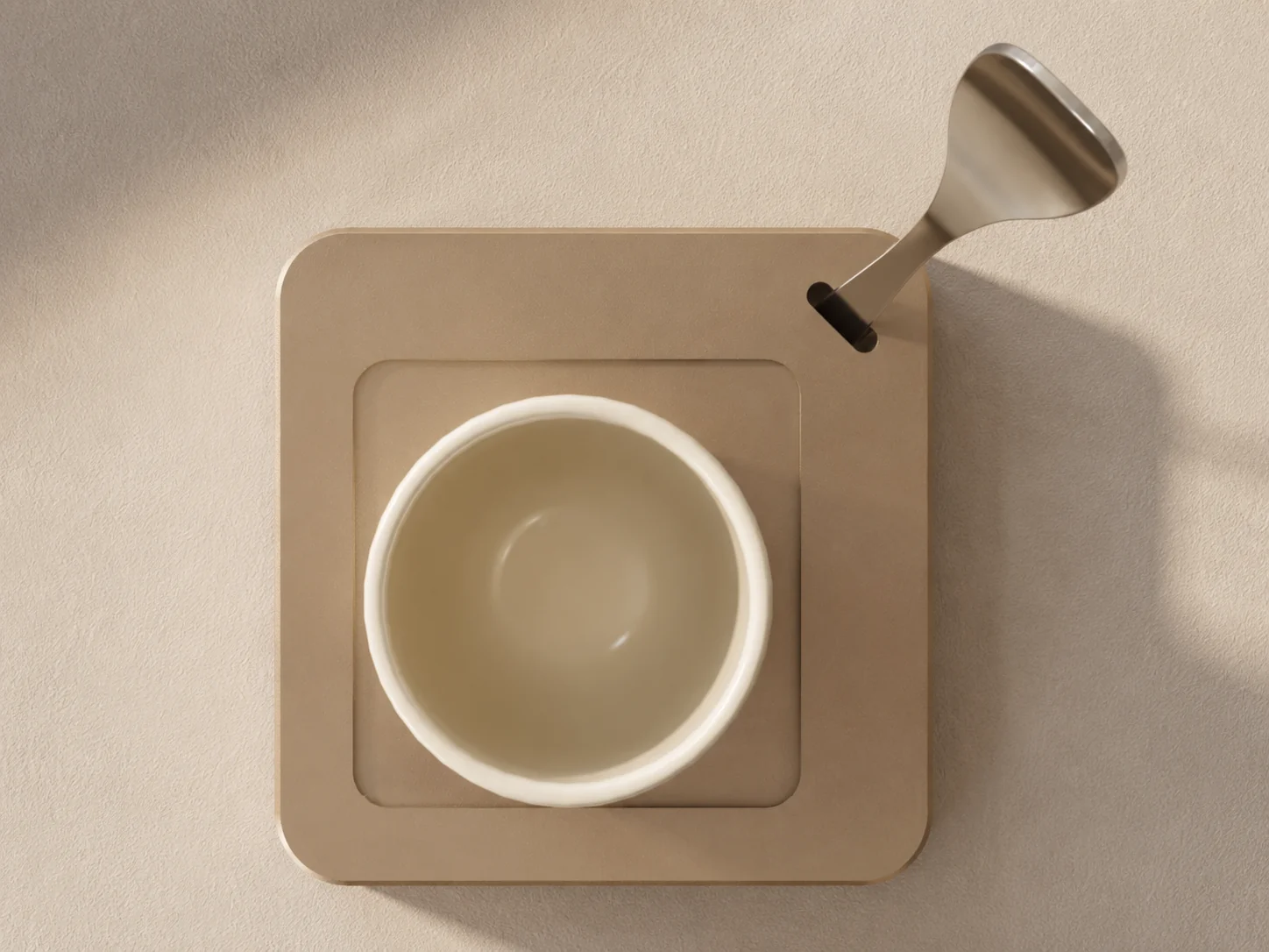 Top-down view of the NOÉ Solo Saucer with a cream cup and docked spoon